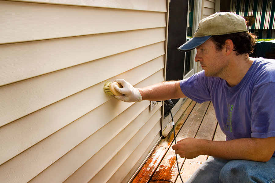A close-up image of white cracked siding on a residential home due to lack of power washing maintenance for this property in Springfield, IL.